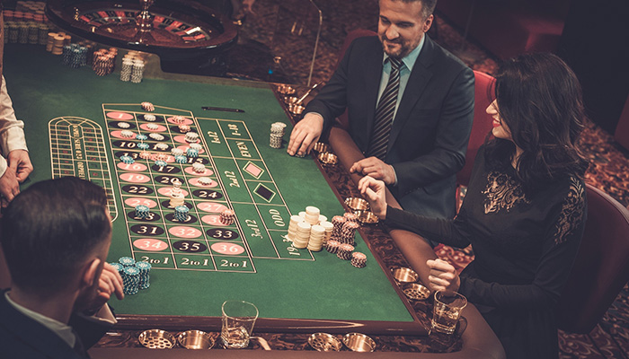 People betting at a Roulette table in a casino