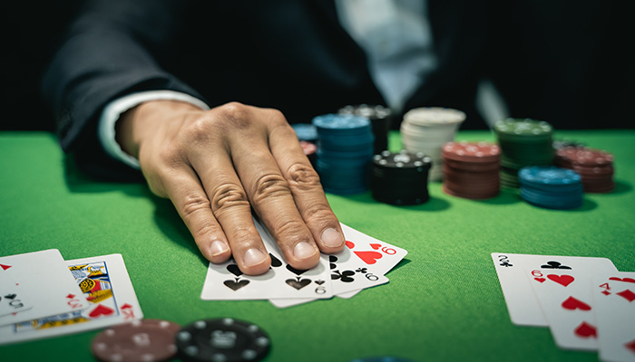 Player holding three cards at a casino table