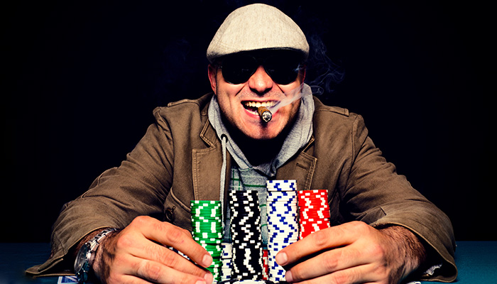 Player at Texas Hold’em table with a stack of poker chips.