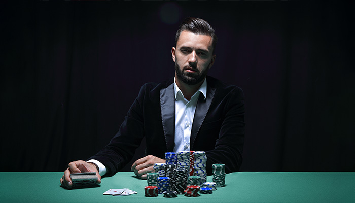 Man sitting on a poker table with Poker Face