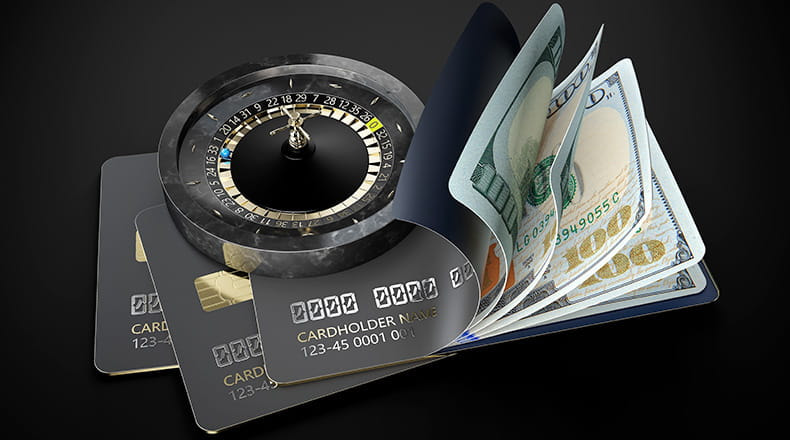 A black marble roulette wheel on a stack of credit cards, and a card slip revealing five $100 bills.