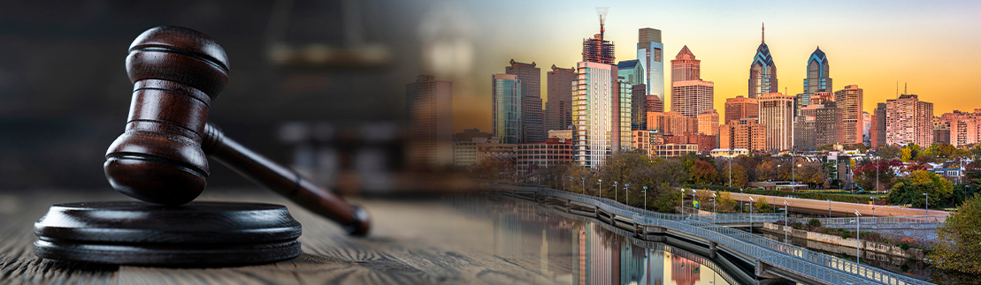 A judge's gavel next to the Philadelphia skyline.