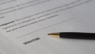 A pen on top of a business agreement document.