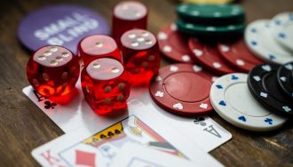 Poker chips, cards, and dice on a table.