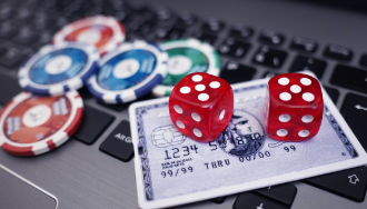 Poker chips, dice, and a credit card on a laptop