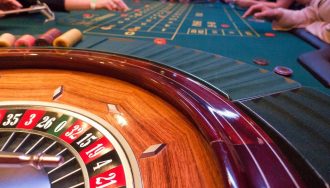 Roulette wheel in a casino, with people gambling