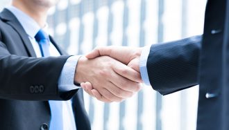 Two Businessmen in Suits Shaking Hands